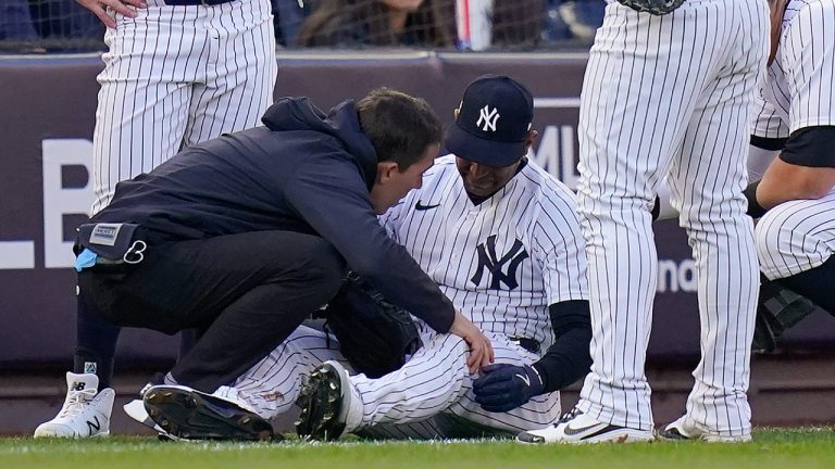 New York Yankees Aaron Hicks is checked by a trainer after colliding with Oswaldo Cabrera on a pop fly during the third inning of Game 5 of an American League Division baseball series against the Cleveland Guardians, Tuesday, Oct. 18, 2022, in New York. (Frank Franklin II/AP)