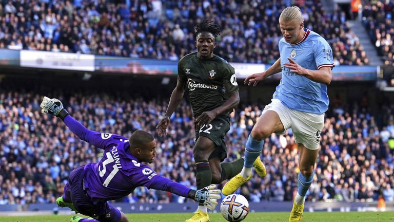 Southampton goalkeeper Gavin Bazunu saves at the feet of Manchester City's Erling Haaland during the English Premier League soccer match between Manchester City and Southampton at Etihad stadium in Manchester, England, Saturday, Oct. 8, 2022. (Martin Rickett/PA via AP)