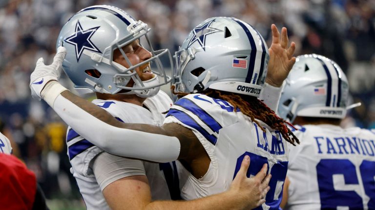 Dallas Cowboys quarterback Cooper Rush, left, and wide receiver CeeDee Lamb (88) celebrate after Rush threw a touchdown pass to Lamb in the second half of a NFL football game against the Washington Commanders. (Ron Jenkins/AP)