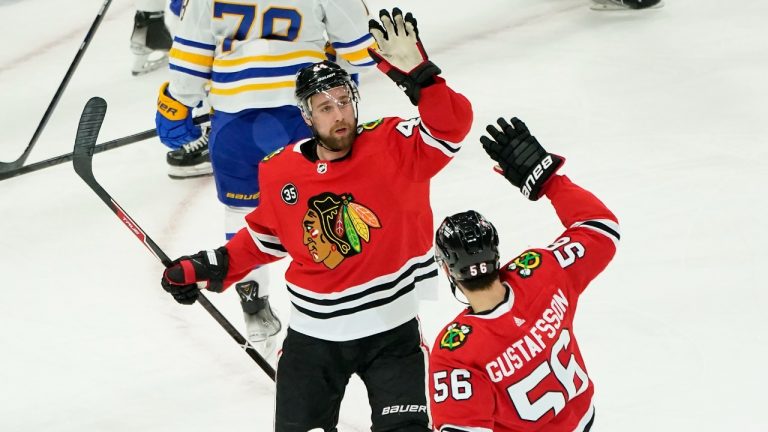 Chicago Blackhawks' Calvin de Haan, left, celebrates his goal with Erik Gustafsson during the first period of an NHL hockey game against the Buffalo Sabres Monday, March 28, 2022, in Chicago. (Charles Rex Arbogast/AP)