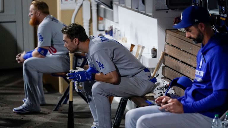 Los Angeles Dodgers' Chris Taylor, center, looks on from the dugout during the third inning in Game 3 of a baseball NL Division Series against the San Diego Padres, Friday, Oct. 14, 2022, in San Diego. (Jae C. Hong/AP) 