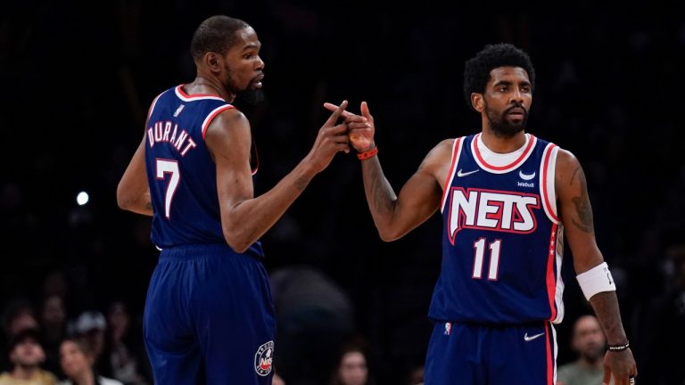 Brooklyn Nets' Kyrie Irving, right, and Kevin Durant celebrate after a basket during the second half of an NBA basketball game against the Indiana Pacers at the Barclays Center, Sunday, April 10, 2022, in New York. The Nets defeated the Pacers 134-126. (AP Photo/Seth Wenig)