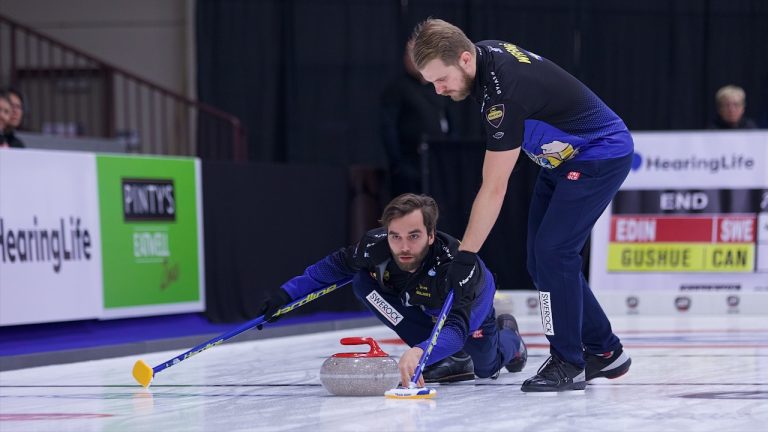 Oskar Eriksson (left) shoots a stone as Rasmus Wrana (right) prepares to sweep during the HearingLife Tour Challenge semifinals on Oct. 22, 2022, at the Coca-Cola Centre in Grande Prairie, Alta. (Anil Mungal/GSOC)