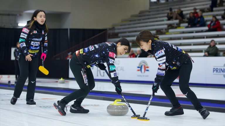 Yurika Yoshida (centre) and Yumi Suzuki (right) sweep a stone for skip Satsuki Fujisawa (left) during Draw 14 action in the HearingLife Tour Challenge on Oct. 21, 2022, at the Coca-Cola Centre in Grande Prairie, Alta. (Anil Mungal/GSOC)