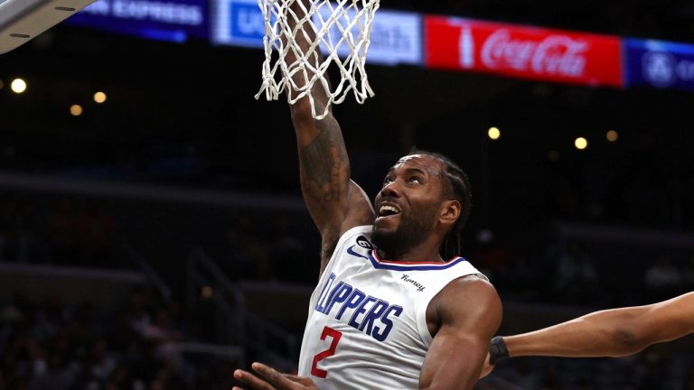 Los Angeles Clippers forward Kawhi Leonard, left, slams dunks the ball past Minnesota Timberwolves center Karl-Anthony Towns, right, during the first half of an NBA preseason basketball game, Sunday, Oct. 9, 2022, in Los Angeles. (AP Photo/Raul Romero Jr.)