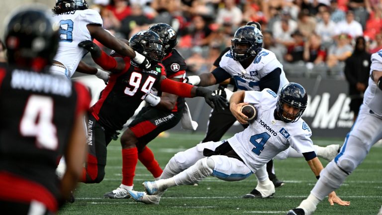 Toronto Argonauts quarterback McLeod Bethel-Thompson (4) falls after being sacked by Ottawa Redblacks defensive end Lorenzo Mauldin IV (94) during first half CFL football action in Ottawa on Saturday, Sept. 10, 2022. (Justin Tang/CP)