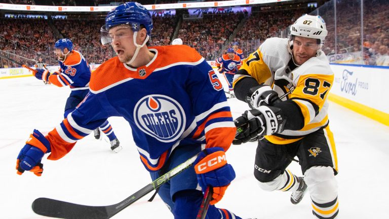 Pittsburgh Penguins' Sidney Crosby (87) hooks Edmonton Oilers' Kailer Yamamoto (56) during second period NHL action in Edmonton on Monday, October 24, 2022. (Jason Franson/CP)