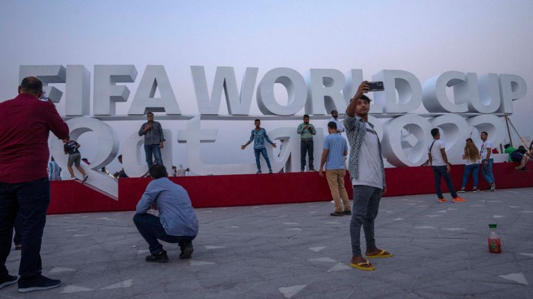 People take photographs in front of a sign representing FIFA World Cup 2022, on Doha's corniche, only 30 days away from the event, in Qatar, Friday, Oct. 21, 2022. (Nariman El-Mofty/AP) 