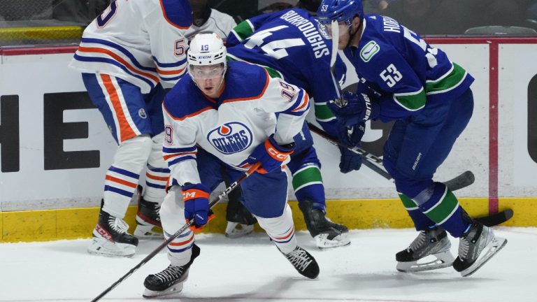 Edmonton Oilers' Jake Virtanen (19) moves the puck in front of Vancouver Canucks' Bo Horvat (53) during the first period of a pre-season NHL hockey game in Abbotsford, B.C., on Wednesday, October 5, 2022. (Darryl Dyck/CP)