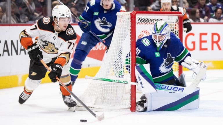 Anaheim Ducks' Frank Vatrano (77) plays the puck near Vancouver Canucks goalie Spencer Martin (30) during the second period of an NHL hockey game in Vancouver on Thursday, November 3, 2022. (Ben Nelms/CP)