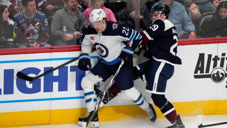 Colorado Avalanche centre Nathan MacKinnon, right, becomes entangled with Winnipeg Jets centre Mason Appleton in overtime of an NHL hockey game Wednesday, Oct. 19, 2022, in Denver. (David Zalubowski/AP Photo)