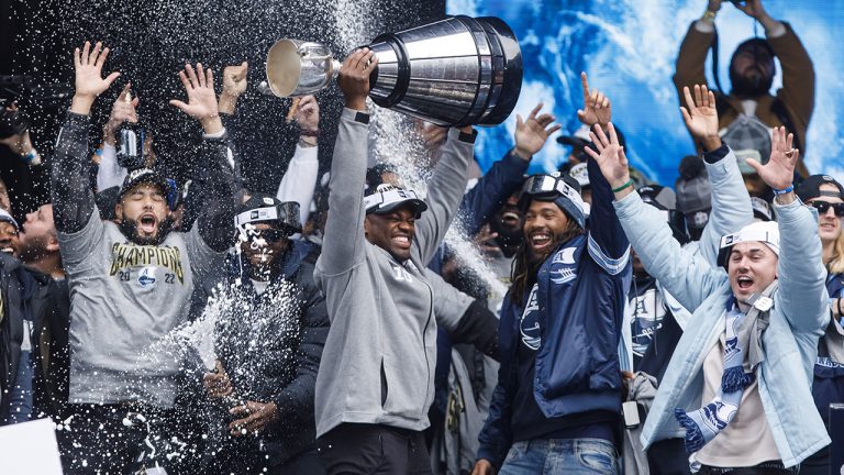 Henoc Muamba, the Grey Cup MVP of the Toronto Argonauts hoists the Grey Cup trophy as he celebrates  during a rally alongside teammates, staff, and fans in downtown Toronto, Thursday, Nov. 23, 2022. (Cole Burston/CP)