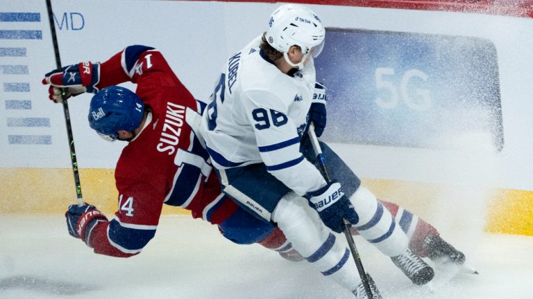 Montreal Canadiens' Nick Suzuki and Toronto Maple Leafs' Nicolas Aube-Kubel slide into the boards during first period NHL hockey action in Montreal, on Wednesday, October 12, 2022. (Paul Chiasson/CP)