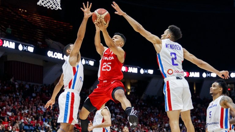 Canada's Trae Bell-Haynes (25) drives to the net between Dominican Republic's Gelvis Solano (4) and Rigoberto Mendoza (2) during second half FIBA international men's World Cup basketball qualifying action, in Hamilton, Ont., on July 1, 2022. He returns for another run with the Canadian senior men's team in the fifth window against Venezuela and Panama (Cole Burston/The Canadian Press)