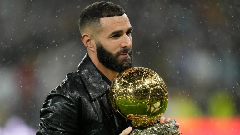 Real Madrid's Karim Benzema holds the 2022 Ballon d'Or trophy prior to the Spanish La Liga soccer match between Real Madrid and Sevilla at the Santiago Bernabeu stadium in Madrid, Saturday, Oct. 22, 2022. (Manu Fernandez/AP Photo)