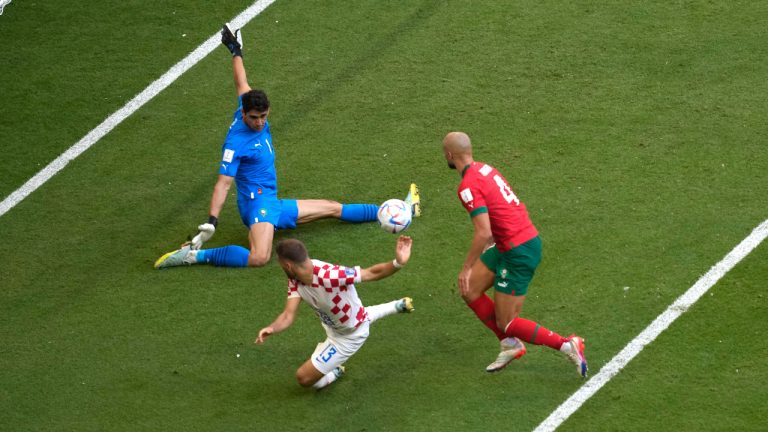 Morocco's goalkeeper Yassine Bounou, left, saves a ball by Croatia's Nikola Vlasic, center, during the World Cup group F soccer match between Morocco and Croatia at the Al Bayt Stadium in Al Khor, Qatar, Wednesday, Nov. 23, 2022. At right is Morocco's Sofyan Amrabat. (Darko Vojinovic/AP)