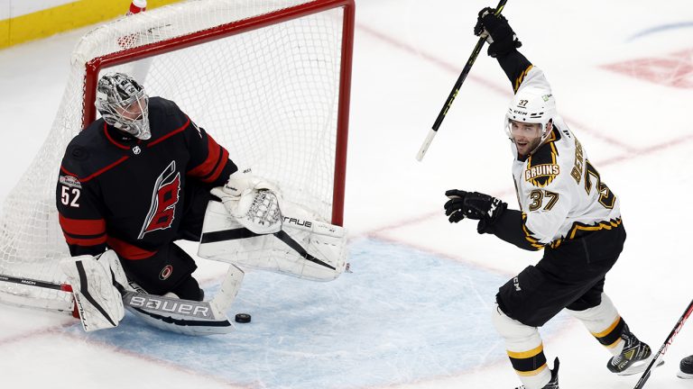 Boston Bruins' Patrice Bergeron (37) celebrates the goal by David Pastrnak against Carolina Hurricanes' Pyotr Kochetkov (52) in overtime during an NHL hockey game, Friday, Nov. 25, 2022, in Boston. (Michael Dwyer/AP)