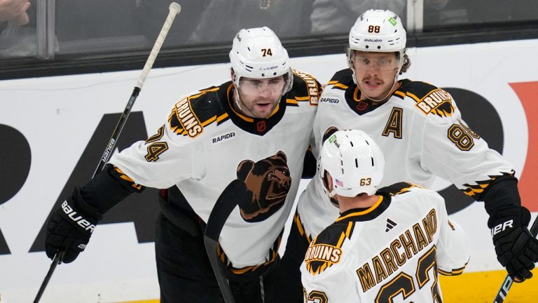 Boston Bruins left wing Jake DeBrusk (74) is congratulated by Brad Marchand (63) and David Pastrnak (88) after his goal against the St. Louis Blues during the first period of an NHL hockey game Monday, Nov. 7, 2022, in Boston. (Charles Krupa/AP)