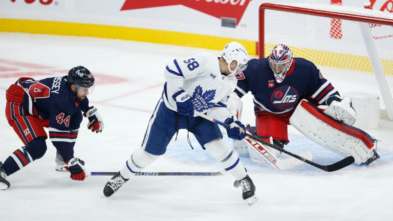 Winnipeg Jets goaltender Connor Hellebuyck (37) makes the save on Toronto Maple Leafs' Michael Bunting (58) as Jets’ Josh Morrissey (44) defends during first period NHL action in Winnipeg. (John Woods/CP)