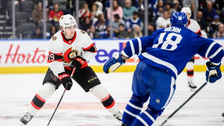 Ottawa Senators right wing Drake Batherson (19) is defended by Toronto Maple Leafs defenceman Jordie Benn (18) during third period NHL pre-season action against the Ottawa Senators, in Toronto, on Saturday, September 24, 2022. THE CANADIAN PRESS/Christopher Katsarov