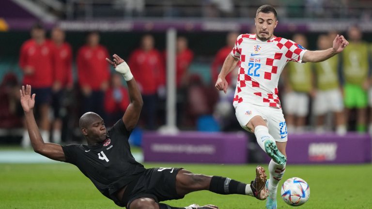 Canada defender Kamal Miller (4) dives to defend as Croatia defender Josip Juranovic (22) plays the ball during first half group F World Cup soccer action at the Khalifa International Stadium in Al Rayyan, Qatar on Sunday, November 27, 2022. THE CANADIAN PRESS/Nathan Denette