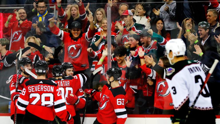 New Jersey Devils center Jack Hughes celebrates with New Jersey Devils left wing Tomas Tatar (90) after scoring a goal against the Arizona Coyotes during the first period of an NHL hockey game, Saturday, Nov. 12, 2022, in Newark, N.J. (AP Photo/Noah K. Murray)