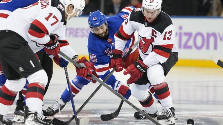 New Jersey Devils center Nico Hischier (13) and New York Rangers center Vincent Trocheck (16) battle for the puck in the third period of an NHL hockey game, Monday, Nov. 28, 2022, in New York. (John Minchillo/AP)