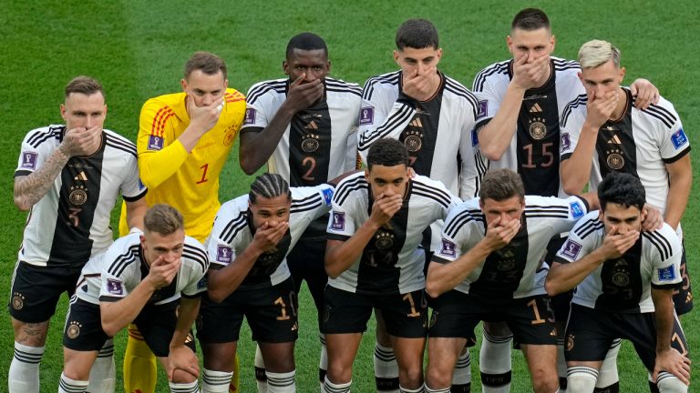 Germany's soccer team players cover their mouths as they pose for a group photo before the World Cup group E soccer match between Germany and Japan. (Ricardo Mazalan/AP)