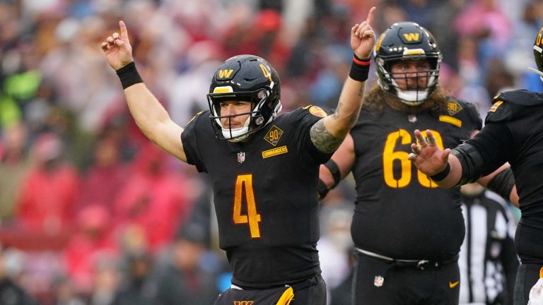 Washington Commanders quarterback Taylor Heinicke raises his arms after throwing a touchdown pass to tight end John Bates during the second half of a game against the Atlanta Falcons, Sunday, Nov. 27, 2022, in Landover, Md. (Patrick Semansky/AP Photo)