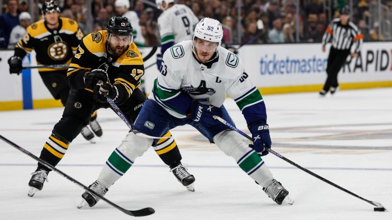 Boston Bruins' Nick Foligno (17) tries to slow down Vancouver Canucks' Bo Horvat during the third period of an NHL hockey game  on Nov. 13, 2022. (AP)