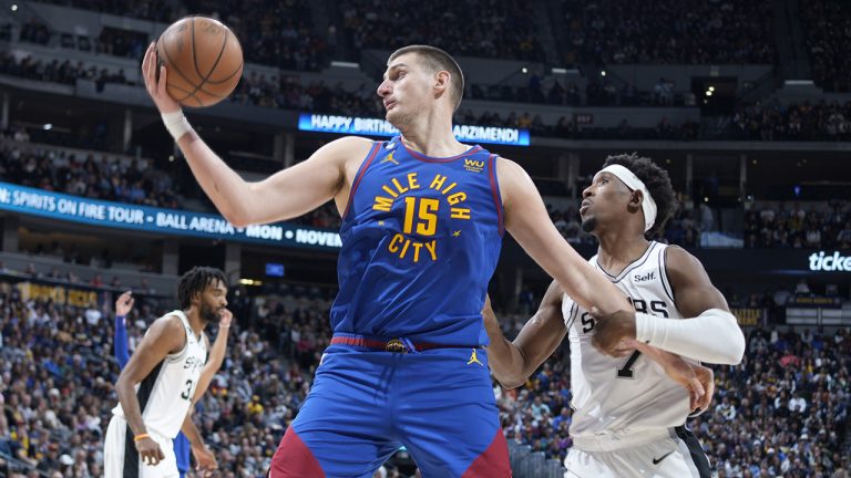 Denver Nuggets center Nikola Jokic, front left, pulls in the ball as San Antonio Spurs guard Josh Richardson, right, defends in the second half of an NBA basketball game Saturday, Nov. 5, 2022, in Denver. (David Zalubowski/AP)