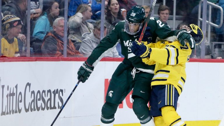 Michigan State left wing Jagger Joshua (23) holds off Michigan defenseman Nick Blankenburg (7) while trying to control the puck during the third period of an NCAA hockey game Monday, Feb. 17, 2020, in Detroit. Michigan defeated Michigan State 4-1. (AP)