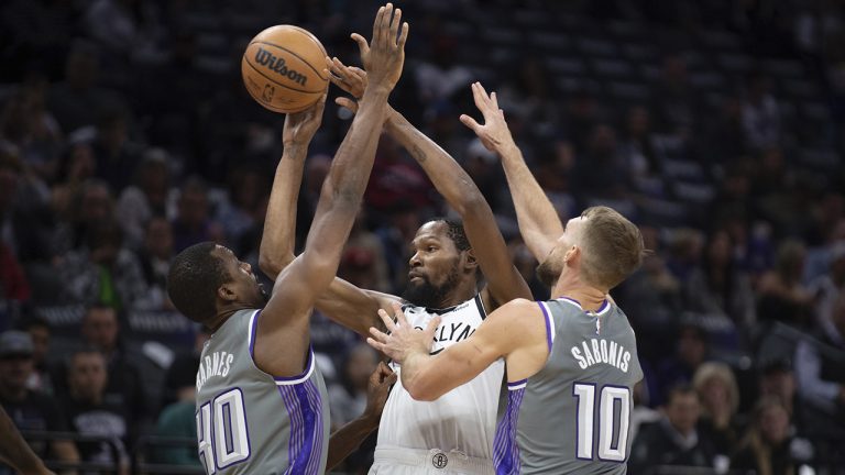 Brooklyn Nets forward Kevin Durant (7) is double teamed by Sacramento Kings forward Harrison Barnes (40) and forward Domantas Sabonis (10) in the first quarter of an NBA basketball game in Sacramento, Calif., Tuesday, Nov. 15, 2022. (Jose Luis Villegas/AP)