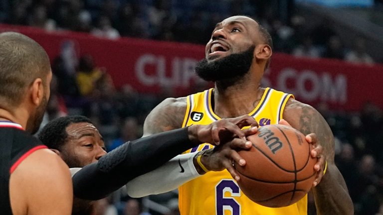 Los Angeles Lakers forward LeBron James, right, tries to shoot while being fouled by Los Angeles Clippers guard John Wall, center, during the first half of an NBA basketball game Wednesday, Nov. 9, 2022, in Los Angeles. (Mark J. Terrill/AP Photo)