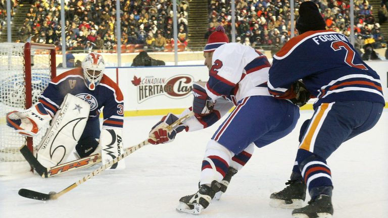 Montreal Canadiens Claude Lemieux, trailed by Edmonton Oilers Lee Fogolin, goes in to score on Edmonton Oilers goalie Grant Fuhr during the Edmonton Oilers and Montreal Canadiens Alumni outdoor exhibition hockey game in Edmonton Saturday, Nov. 22, 2003.(Adrian Wyld/CP)