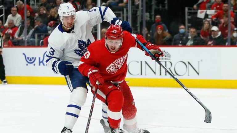 Toronto Maple Leafs defenseman Justin Holl (3) tries to go over the top for the puck being advanced by Detroit Red Wings left wing Adam Erne (73) during the third period of an NHL hockey game Saturday, Jan. 29, 2022, in Detroit. (Duane Burleson/AP)