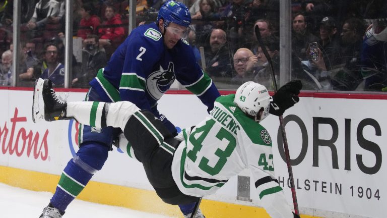 Vancouver Canucks' Luke Schenn (2) checks Dallas Stars' Marian Studenic (43), of Slovakia, during the third period of an NHL hockey game in Vancouver, B.C., Monday, April 18, 2022. (Darryl Dyck/CP)