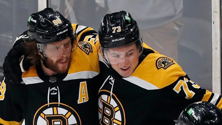 Boston Bruins' David Pastrnak (88) celebrates his goal with Charlie McAvoy (73) and Brad Marchand (63) during the first period of an NHL hockey game against the New York Rangers, Saturday, April 23, 2022, in Boston. (Michael Dwyer/AP)