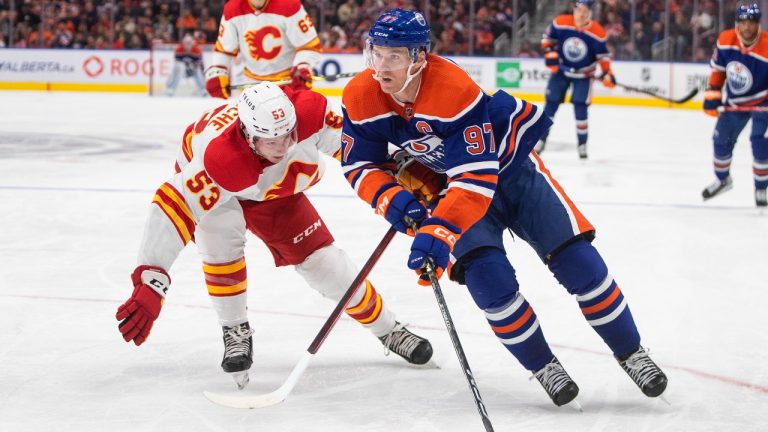 Calgary Flames' Nicolas Meloche (53) chases Edmonton Oilers' Connor McDavid (97) during second period pre-season action in Edmonton on Friday, September 30, 2022. (Jason Franson/CP)