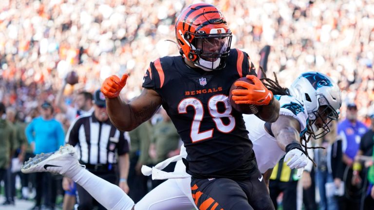 Cincinnati Bengals running back Joe Mixon (28) runs past Carolina Panthers linebacker Shaq Thompson, right, for a touchdown during the second half of an NFL football game, Sunday, Nov. 6, 2022, in Cincinnati. (Joshua A. Bickel/AP Photo)