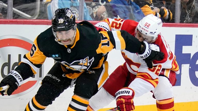 Pittsburgh Penguins' Jason Zucker (16) works to gain control of the puck with Calgary Flames' MacKenzie Weegar (52) defending during the second period of an NHL hockey game in Pittsburgh, Wednesday, Nov. 23, 2022. (Gene J. Puskar/AP)