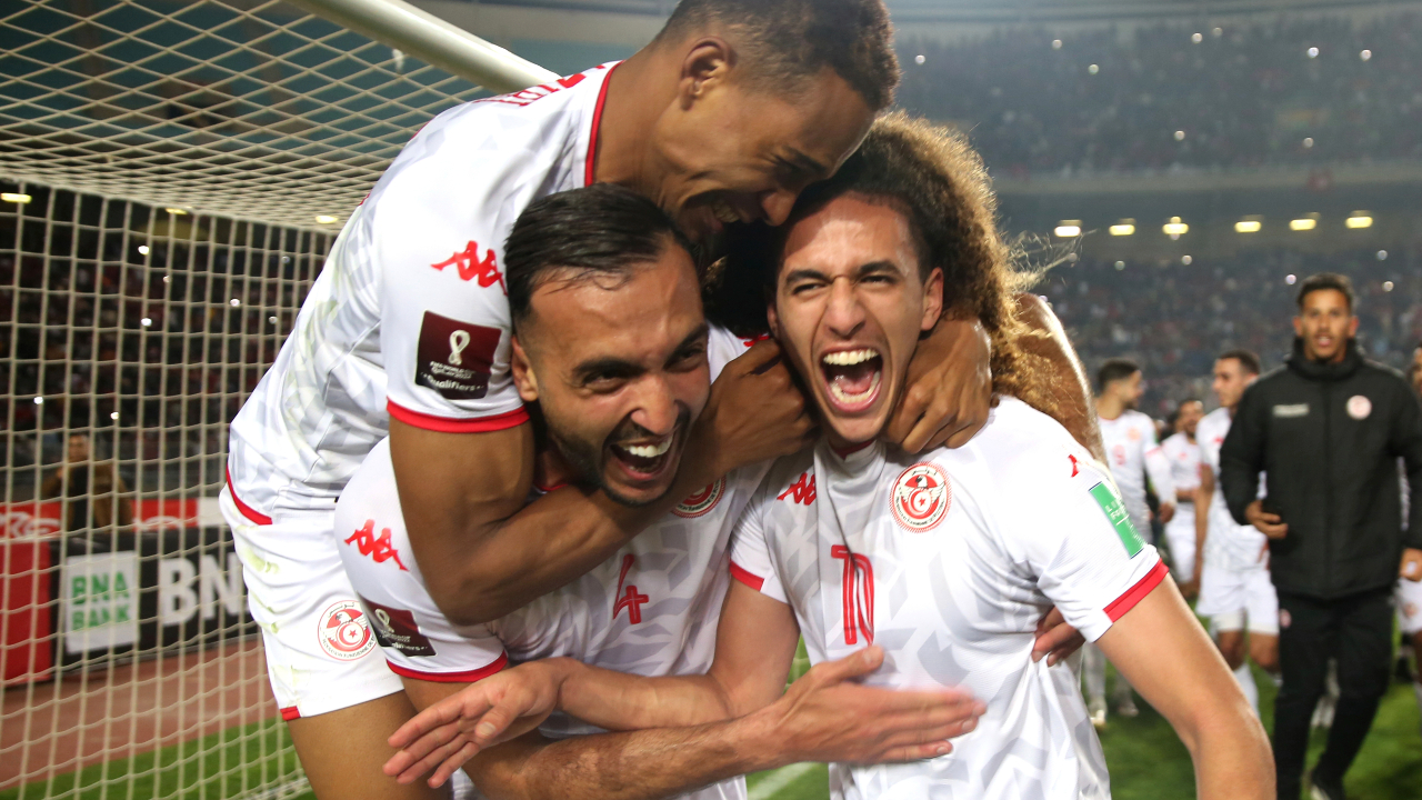 Tunisia players Hannibal Jegham, right, Nader Ghandri, centre, and Seifeddine Jaziri , left, celebrate after qualifying to World Cup 2022 after their match against Mali, at the Olympic stadium in Rades, Tunisia, Tuesday, March 29, 2022. (Hassene Dridi/AP)