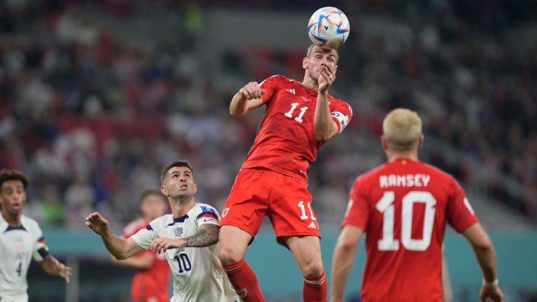 Wales' Gareth Bale heads the ball away from Christian Pulisic of the United States, during the World Cup, group B soccer match between the United States and Wales, at the Ahmad Bin Ali Stadium in in Doha, Qatar, Monday, Nov. 21, 2022. (Darko Vojinovic/AP)