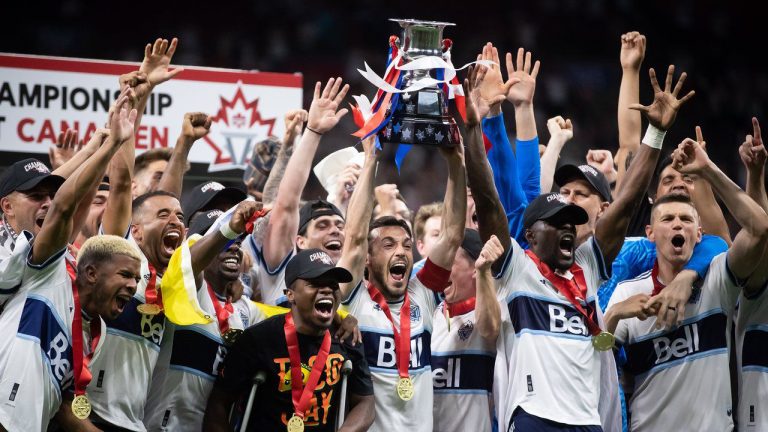 Vancouver Whitecaps' Russell Teibert, centre, hoists the Voyageurs Cup after Vancouver defeated Toronto FC in penalty kicks during the Canadian Championship soccer final, in Vancouver, on Tuesday, July 26, 2022. (Darryl Dyck/CP)
