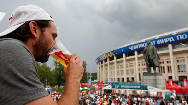 In this July 11, 2018 photo, a man drinks a beer in a Budweiser pavilion in front of the Lenin statue and the Luzhniki Stadium as fans arrive for the semifinal match between Croatia and England, during the 2018 soccer World Cup in Moscow, Russia. The sale of all beer with alcohol at the eight World Cup stadiums in Qatar has been banned. The decision comes only two days before the soccer tournament is set to start. Non-alcoholic beer will still be available for fans at the 64 matches. FIFA says the decision was made "following discussions between host country authorities and FIFA." (Rebecca Blackwell, File/AP)