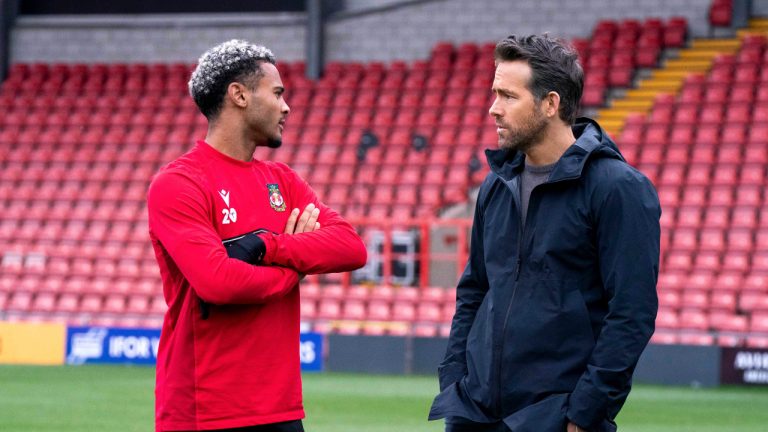 This image released by FX shows Dior Angus, left, and Ryan Reynolds in a scene from the docuseries "Welcome to Wrexham," which follows owners Reynolds and Rob McElhenney as they takeover the lower-league Welsh soccer team Wrexham AFC. (Patrick McElhenney/FX via AP)