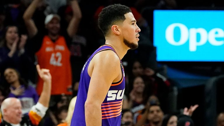 Phoenix Suns fans cheer on Suns guard Devin Booker after he scored against the Chicago Bulls during the second half of an NBA basketball game in Phoenix, Wednesday, Nov. 30, 2022. The Suns won 132-113. (AP Photo/Ross D. Franklin)