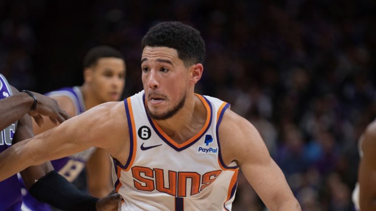 Phoenix Suns guard Devin Booker (1) gets past Sacramento Kings guard Terence Davis (3) in the second half of an NBA basketball game in Sacramento, Calif., Monday, Nov. 28, 2022. The Suns won 122 - 117. (AP Photo/Jose Luis Villegas)