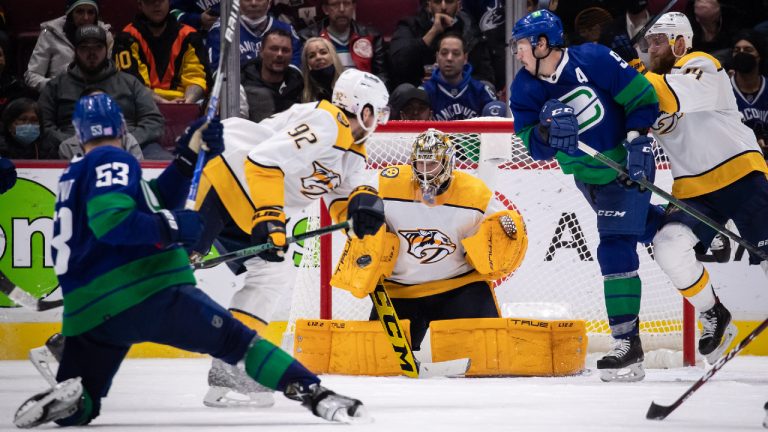 Vancouver Canucks' Bo Horvat (53) is stopped by Nashville Predators goalie Juuse Saros, of Finland, as Mattias Ekholm, right, of Sweden, checks Vancouver's J.T. Miller (9) while Ryan Johansen (92) watches during the third period of an NHL hockey game in Vancouver, on Friday, November 5, 2021. (Darryl Dyck/CP)