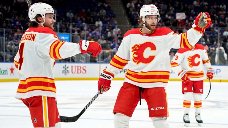 Calgary Flames defenseman Rasmus Andersson (4) and defenseman Noah Hanifin (55) celebrate center Elias Lindholm's goal during the first period of an NHL hockey game against the New York Islanders. (AP)